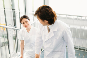 Obraz premium 病院内を歩く白衣姿の男女（看護師） 