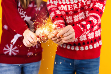 couple of young latin friends having fun with sparklers for Christmas party or mexican posada in...
