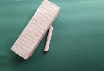 Chalk and duster or eraser on the green background. Method of education, teaching. Teaching method, education system, India.