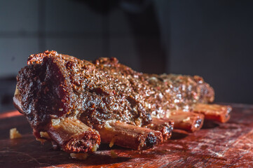 Spicy grilled summer barbecue cutlets served with an antique vintage wooden cutting board,selective focus.and copy space