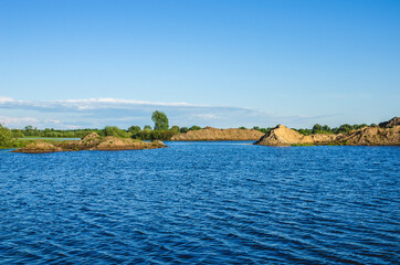 The excavated soil and the top layer of sand formed dumps in the sand pit. Extraction of sand from the lake