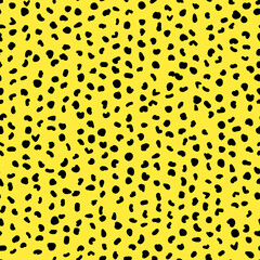 Abstract seamless pattern from small shapes. Simple background of irregular spots. Abstract wild animal skin print. Random spaced black spots. Vector illustration on yellow background