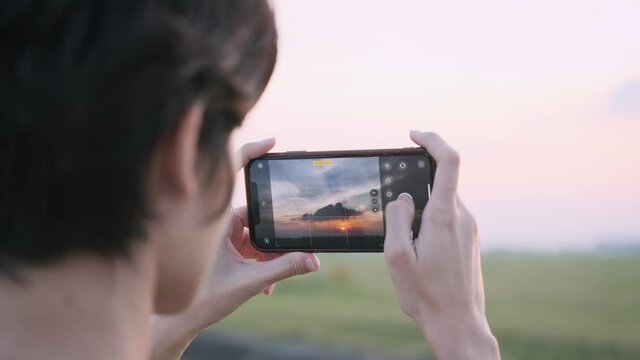 Female Hands Holding Smartphone and Doing Nature Photography. Young Tourist Woman Taking Photos with Mobile Phone Camera of Amazing Sunset 