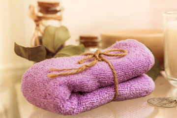 Fototapeta na wymiar Folded lilac towel on spa relaxing bath background. Body treatment