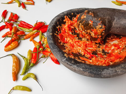 Sambal or traditional chili sauce from Indonesia, freshly made using stone mortar and pestle. Bird's eye chili spread around