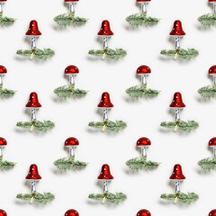 Christmas pattern with botanical ornaments fly agaric mushrooms with red cap and white dots, on natural green christmas fir tree branches on white background. Holiday winter decor