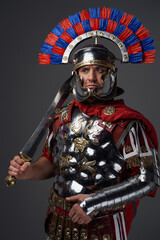 Antique pensive legionary posing against gray studio background