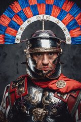 Fototapeta na wymiar Studio shot of fearful roman soldier with colorful plumed helmet