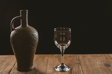 jug with wine and a glass on a wooden table