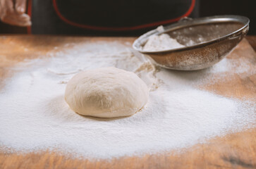 Baker kneading dough. Chef cook making dough for baking pie on wooden table. Process preparation homemade pastry. Cooking pasta, bread,spaghetti,khachapuri, food concept