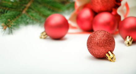 Close up red Christmas ornaments and green Christmas tree branches on white background
