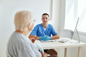 Obraz premium elderly woman patient talking to doctor professional consultant