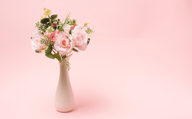 Flowers bouquet in a white vase laying on a light pink background. Minimal studio view