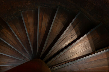 A wooden spiral staircase on an old steel structure.