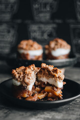 Apple crumble dessert on black plate