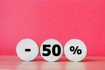 Percent sign on wooden figure against red background with copy space. Concept of sale and discount.