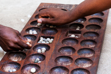 Hands playing Mancala game, Stone town, Tanzania. Mancala is a game which is very popular in Africa...