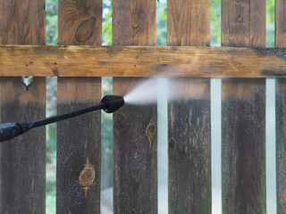 Sanitary cleaning private territory and wooden fence with equipment pressure washer, containing a...