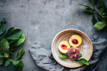 Peaches in rustic bowl on background