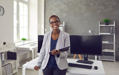 Portrait of happy successful satisfied young business lady at work. Beautiful black woman with...