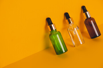 Dropper glass bottles with pipette. Transparent hyaluronic natural beauty mineral product and eco serum skin care concept. Top horizontal view copyspace. Summer juicy colors.