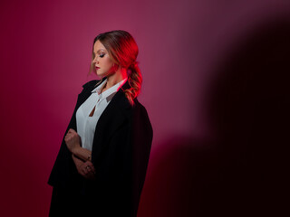 A young stylish woman in a business suit, fashion shooting in red tones