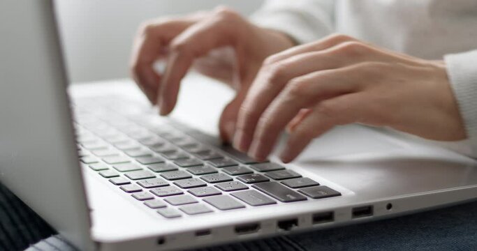 Female fingers are typing text on the laptop keyboard. Business woman works using a computer. Close-up.