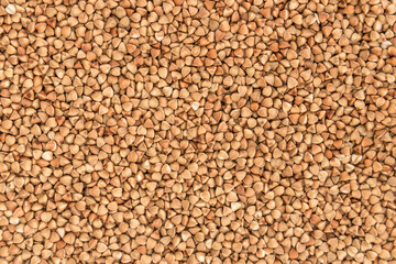 Background, texture, the rump. Buckwheat grains. Roasted buckwheat. Useful properties of buckwheat. Garnish. Ingredient, product, cook. Brown. crop, organic farming. Dietary product. Close up.