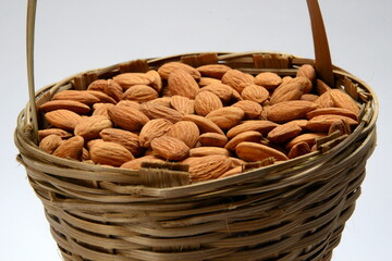 Fresh almonds in the wooden bowl, Organic almonds, almonds border white background, Almond nuts on a dark wooden background. Healthy snacks. Top view. Free space for text.