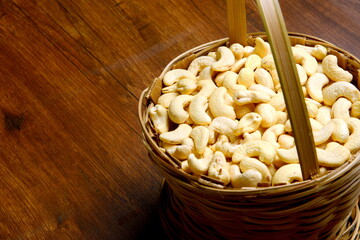 Roasted salted raw cashew nuts in wooden bowl on rustic table, healthy vegetarian snack, Anacardium occidentale, Cashews on white background, Cashews nut background,Bowl with casheFree space for text.