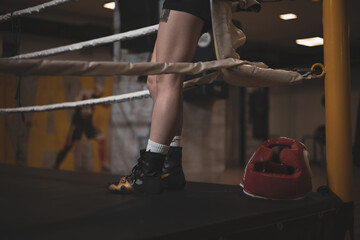 
the detail of the legs of a girl ascended to a boxing ring.