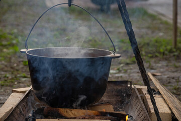 Hiking pot in the bonfire. Traveling in the mountains with tents