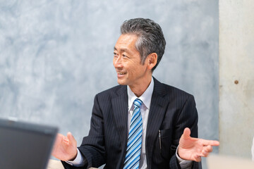 スーツで意見を述べる経営者