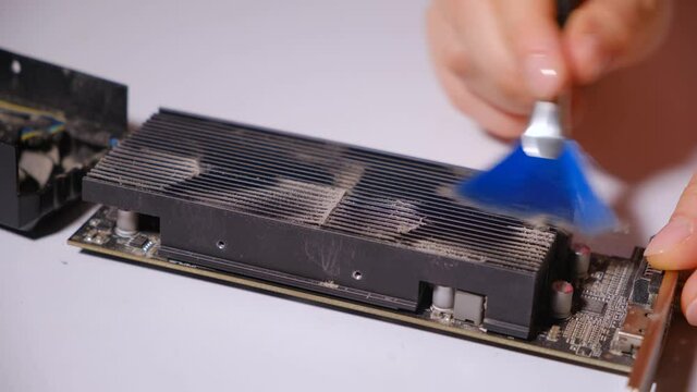 Computer wizard brushes the video card from dust.