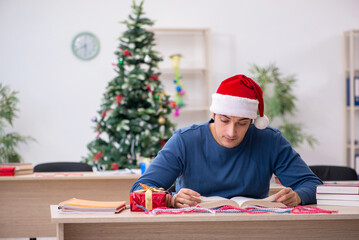 Young male student preparing for exams during new year celebrati