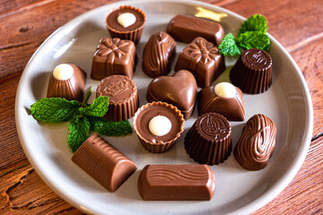 Assorted chocolates on a gray dish, milk chocolate, dark and white