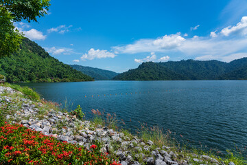 landscape photo of mountains, sky and water in the dam.