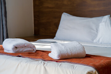 Fototapeta na wymiar Clean towel on bed in modern interior bedroom