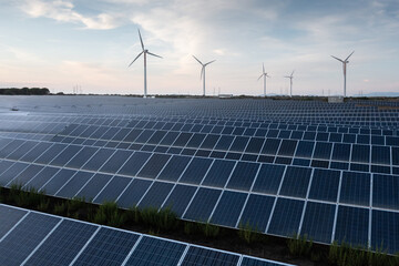 Solar panels and wind turbines producing green energy for clean environment.