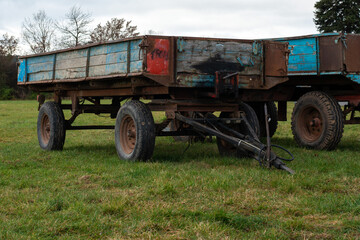 Fototapeta na wymiar Old agricultural transport trailers in blue and red