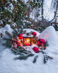 Weihnachtliche Deko mit Laterne im verschneiten Garten
