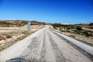 Road in the mountains.A long road to eternity. Perspective view of an asphalt road in the countryside.A lonely road towards the blue sky. Selective focus. Noise effect.