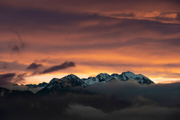 Fototapeta na wymiar dark afterglow at sunset over the fog-shrouded austrian alps mountains in autumn