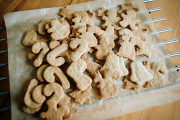 Gingerbread christmas cookies cutters and rolling pin over wooden pastry board