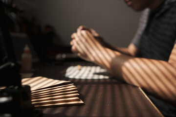 Cork sheets of different gauges on a table and man working in the background