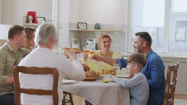 Company of caucasian family drinking wine glasses and chatting. Happy people laughing and talking in the summer evening while kids sitting nearby