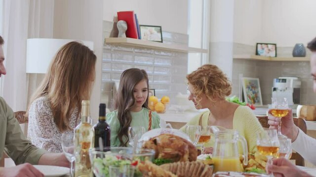 Happy friends having dinner together with each other and with their kids at home indoor. Relationships and holidays concept