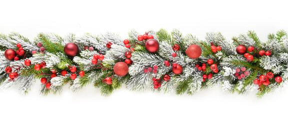Christmas banner with red baubles and holly berry in row on snowy evergreen fir branches isolated on white background. Wide size.