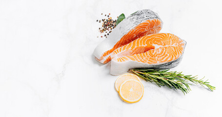 two raw salmon steaks on a white marble surface. the concept of a healthy dinner for two from salmon steaks. fresh salmon steaks.