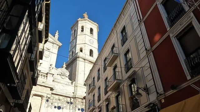 Soleado campanario de la catedral de Valladolid visto desde una calle en sombra aledaña al templo de estilo herreriano y barroco
